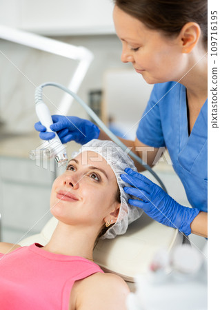 Beautiful female doctor making facial gas-liquid oxygen water epidermal peeling using professional equipment use macromolecule atomizing pen for young girl at spa salon. Skin care concept. Beauty 109716195