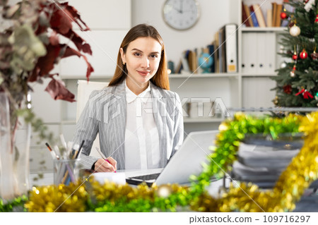 Successful business woman using laptop at workplace during christmas Successful business woman using laptop at workplace during christmas 109716297