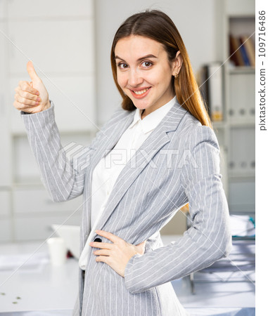 Business woman standing in office and pointing 109716486