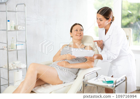 Woman doctor give patient medical documents for review before carrying out cosmetic procedure 109716994