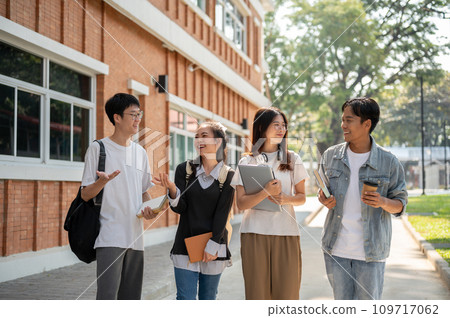 Group of diverse cheerful Asian students friends are enjoying talking while walking in their campus. 109717062