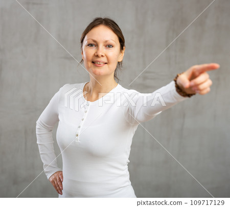 Smiling adult woman gesturing in studio Smiling adult woman gesturing in studio 109717129