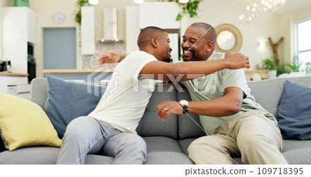 Hug, talking and a father and son on the sofa for a visit, bonding or gratitude. Happy, house and an African dad embracing an adult man for greeting, love or care during a conversation on the couch 109718395