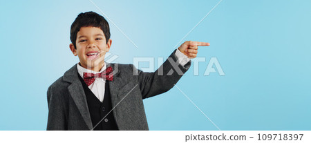 Pointing, face or happy child in studio for offer, discount deal or retail sale on mockup space or logo advertising. Business, funny or excited boy with smile, news or kids promo on blue background Pointing, face or happy child in studio for offer, discount deal or retail sale on mockup space or logo advertising. Business, funny or excited boy with smile, news or kids promo on blue background 109718397