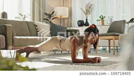 Woman, breathe and plank exercise in home for strong workout, fitness and balance body. Serious indian girl, training challenge and push up on elbow for muscle, power and action on floor in lounge Woman, breathe and plank exercise in home for strong workout, fitness and balance body. Serious indian girl, training challenge and push up on elbow for muscle, power and action on floor in lounge 109718405