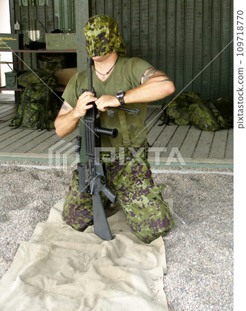 Army, training to assemble a gun with a man soldier outdoor in camouflage uniform for an exercise. Military, blindfold and a trooper person at bootcamp to build a weapon or rifle in record time Army, training to assemble a gun with a man soldier outdoor in camouflage uniform for an exercise. Military, blindfold and a trooper person at bootcamp to build a weapon or rifle in record time 109718770