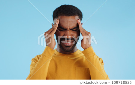 Stress, tired and a man with headache pain on a blue background from burnout or anxiety. Mental health, fatigue and a person with a migraine massage, frustrated and with depression and anger 109718825