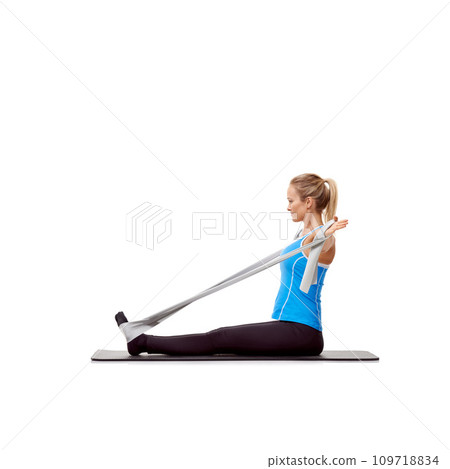 Fitness, resistance band and woman doing exercise in studio for health, wellness and bodycare. Sport, yoga mat and young female person from Australia with arms workout or training by white background Fitness, resistance band and woman doing exercise in studio for health, wellness and bodycare. Sport, yoga mat and young female person from Australia with arms workout or training by white background 109718834