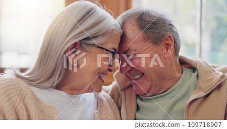 Senior couple, happy and smiling with laugh and talking with embrace, couch and retired. Retirement, old age home and elderly in living room, couch and bonding together for quality time, hug or care 109718907