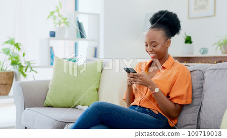 Relax, phone chat or black woman on sofa in communication in house living room. Smile, scroll or happy African person texting or reading online gossip on a mobile app discussion on couch at home Relax, phone chat or black woman on sofa in communication in house living room. Smile, scroll or happy African person texting or reading online gossip on a mobile app discussion on couch at home 109719018