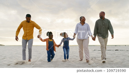 Love, travel and holding hands with black family at beach for summer, vacation and relax. Holiday, support and happy with parents and children walking on coastline for care, trust and freedom Love, travel and holding hands with black family at beach for summer, vacation and relax. Holiday, support and happy with parents and children walking on coastline for care, trust and freedom 109719390