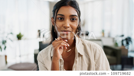 Portrait, smile and Indian woman in a living room for remote work, break or relax in her home. Happy, face and calm female freelance chilling in a lounge with good mood, confidence and chilling 109719682