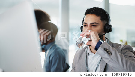 Happy businessman, call center and drinking water in customer service or telemarketing at office. Thirsty man, consultant or agent talking with headphones and drink for online advice, support or help 109719716