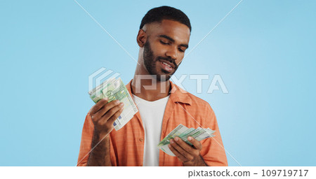Man, count cash and happy in studio with success, bonus or promotion with winning by blue background. Investor, trader or person with Euro money, salary or savings with smile for financial freedom go 109719717