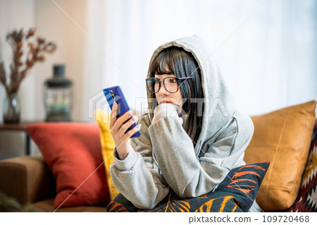 一個操作智能手機的年輕女子 109720468