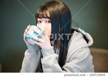 Woman drinking coffee at the dining table 109720695