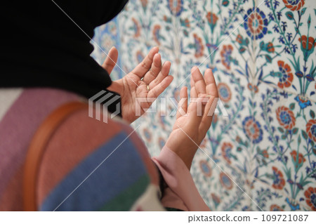 Muslim young woman in hijab is praying in mosque. Muslim young woman in hijab is praying in mosque. 109721087