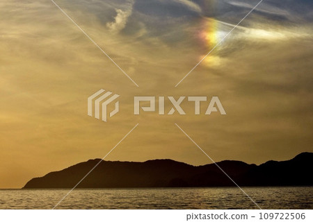 A rainbow phantom sun appears next to the sunset over the sea A rainbow phantom sun appears next to the sunset over the sea 109722506