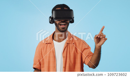 Man, virtual reality and glasses in studio with hand, click and swipe with smile for metaverse by blue background. Person, AR vision and futuristic game with 3D user experience, cyber ui and esports Man, virtual reality and glasses in studio with hand, click and swipe with smile for metaverse by blue background. Person, AR vision and futuristic game with 3D user experience, cyber ui and esports 109723602