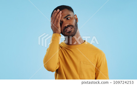 Stress, fail and man in studio with facepalm emoji for stupid mistake or regret on blue background. Anxiety, oops and male model with disaster, crisis or fake news shame, frustrated and unhappy 109724253