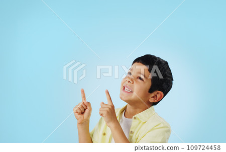 Kid, boy and smile while pointing in studio on blue background with mockup for announcement, offer or deal. Youth, happy and excited about notification on social media, online or digital marketing Kid, boy and smile while pointing in studio on blue background with mockup for announcement, offer or deal. Youth, happy and excited about notification on social media, online or digital marketing 109724458