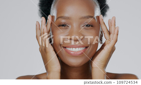 Face touch, skincare and happy black woman in studio isolated on a gray background for dermatology. Portrait, hands and natural beauty cosmetics of model in spa facial treatment, wellness and health Face touch, skincare and happy black woman in studio isolated on a gray background for dermatology. Portrait, hands and natural beauty cosmetics of model in spa facial treatment, wellness and health 109724534