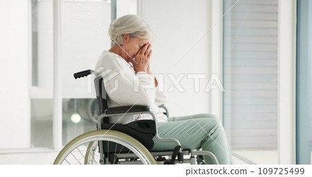 Sad, senior woman and person with disability, wheelchair and crying into hands at the hospital, window or nursing home. Depressed, mental health and elderly person frustrated, thinking in retirement 109725499
