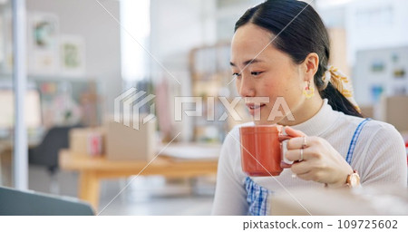 Ecommerce, Asian woman at laptop with coffee and boxes, checking sales email or work at fashion startup. Online shopping, distribution and small business owner with drink, computer and review at desk 109725602