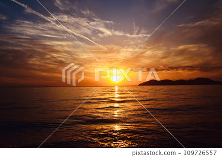The sunset over the reddish sea on a day when a rainbow appeared 109726557