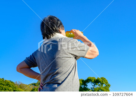 Senior woman drinking strong green tea while walking, Shinryoku Park, diet, exercise, healthy habits, walk, trimmed up 109727604