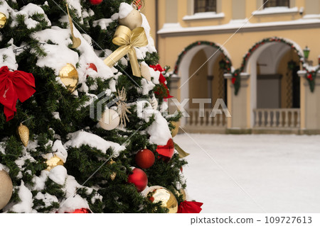 Close-up of a decorated Christmas tree standing outside in the snow Close-up of a decorated Christmas tree standing outside in the snow 109727613