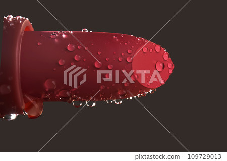 Red lipstick with water drops on a dark background. 109729013