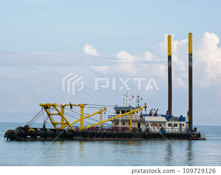 a large floating dredging excavator on sea coast a large floating dredging excavator on sea coast 109729126