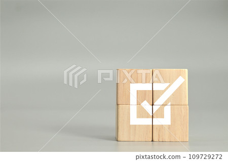wooden cubes with checkmark icon on gray background 109729272