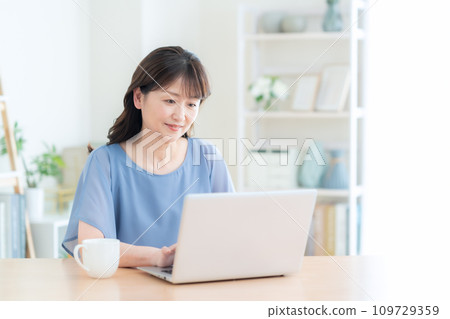 Middle-aged woman using a computer in the living room 109729359
