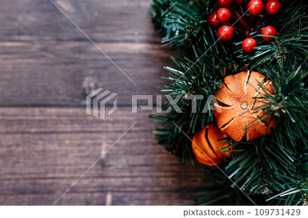 christmas background pine tree with dried tangerines wooden background. The combination of the pine tree, ornaments, and greenery creates a classic and cozy setting. christmas background pine tree with dried tangerines wooden background. The combination of the pine tree, ornaments, and greenery creates a classic and cozy setting. 109731429