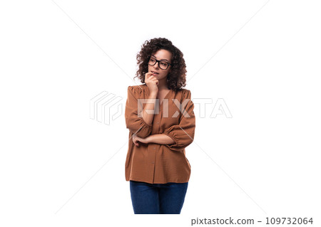 young pensive caucasian lady with curly hair is wearing a brown blouse 109732064
