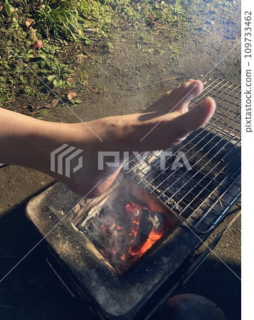 一個女人在木炭上烤腳 一個女人在木炭上烤腳 109733462