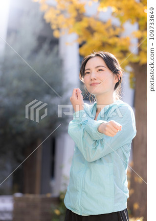 Autumn/winter image of a young woman exercising in the autumn leaves Autumn/winter image of a young woman exercising in the autumn leaves 109733649