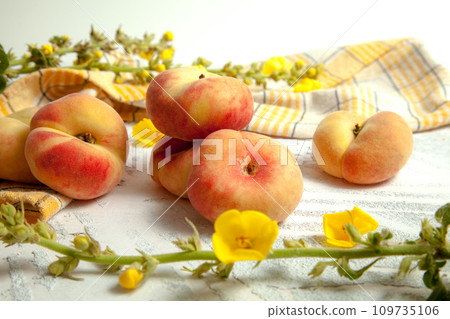 Several whole saturn peaches or flat peach on white wooden background.. 109735106