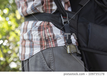 A bear bell attached to a black backpack 109735178