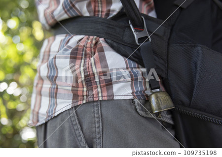A bear bell attached to a black backpack A bear bell attached to a black backpack 109735198