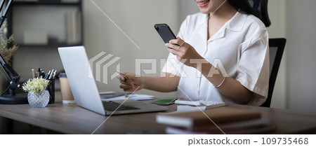 Woman on desk with smartphone, credit card and ecommerce payment for online shopping at home. digital bank app and sale on store website with internet banking Woman on desk with smartphone, credit card and ecommerce payment for online shopping at home. digital bank app and sale on store website with internet banking 109735468
