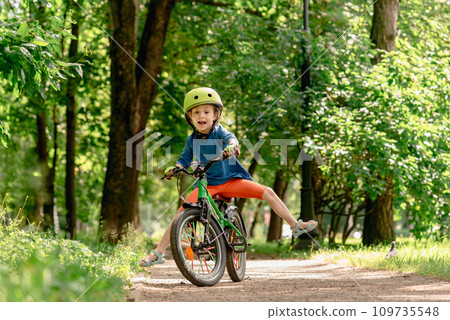 A child learning to ride a bicycle is unable to maintain balance and falls down. A child learning to ride a bicycle is unable to maintain balance and falls down. 109735548