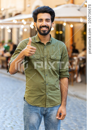 Happy man showing thumbs up, like sign positive something good positive feedback in city street Happy man showing thumbs up, like sign positive something good positive feedback in city street 109736678