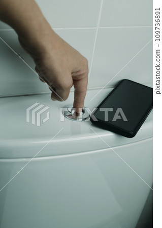 man flushing the toilet after using it 109736891