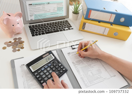 Tax concept with laptop and US tax forms Tax concept with laptop and US tax forms 109737332
