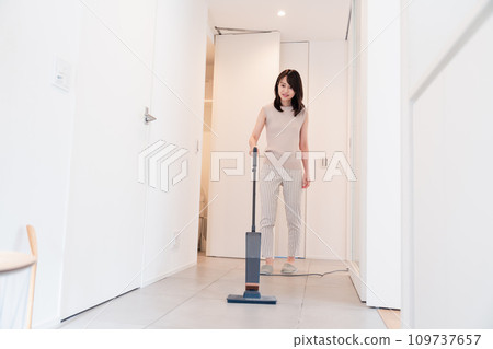 用吸塵器打掃房子的年輕女人 109737657