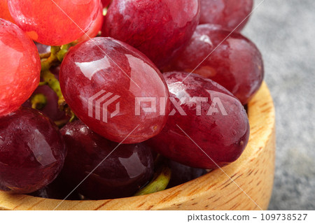 Close up Fresh red grapes on a wooden cup 109738527