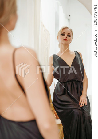 Woman in black dress on white background in the studio. Elegant lady in long gown. Sexy girl in formal prom dress. Woman in black dress on white background in the studio. Elegant lady in long gown. Sexy girl in formal prom dress. 109738761